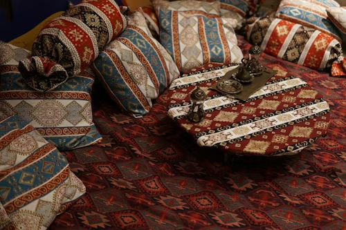 Coussins brodés en soie et velours marocain disposés dans un salon traditionnel