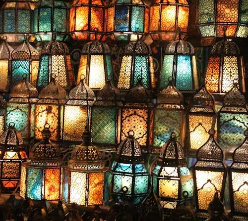 Lanternes marocaines en laiton et verre coloré projetant des motifs sur les murs